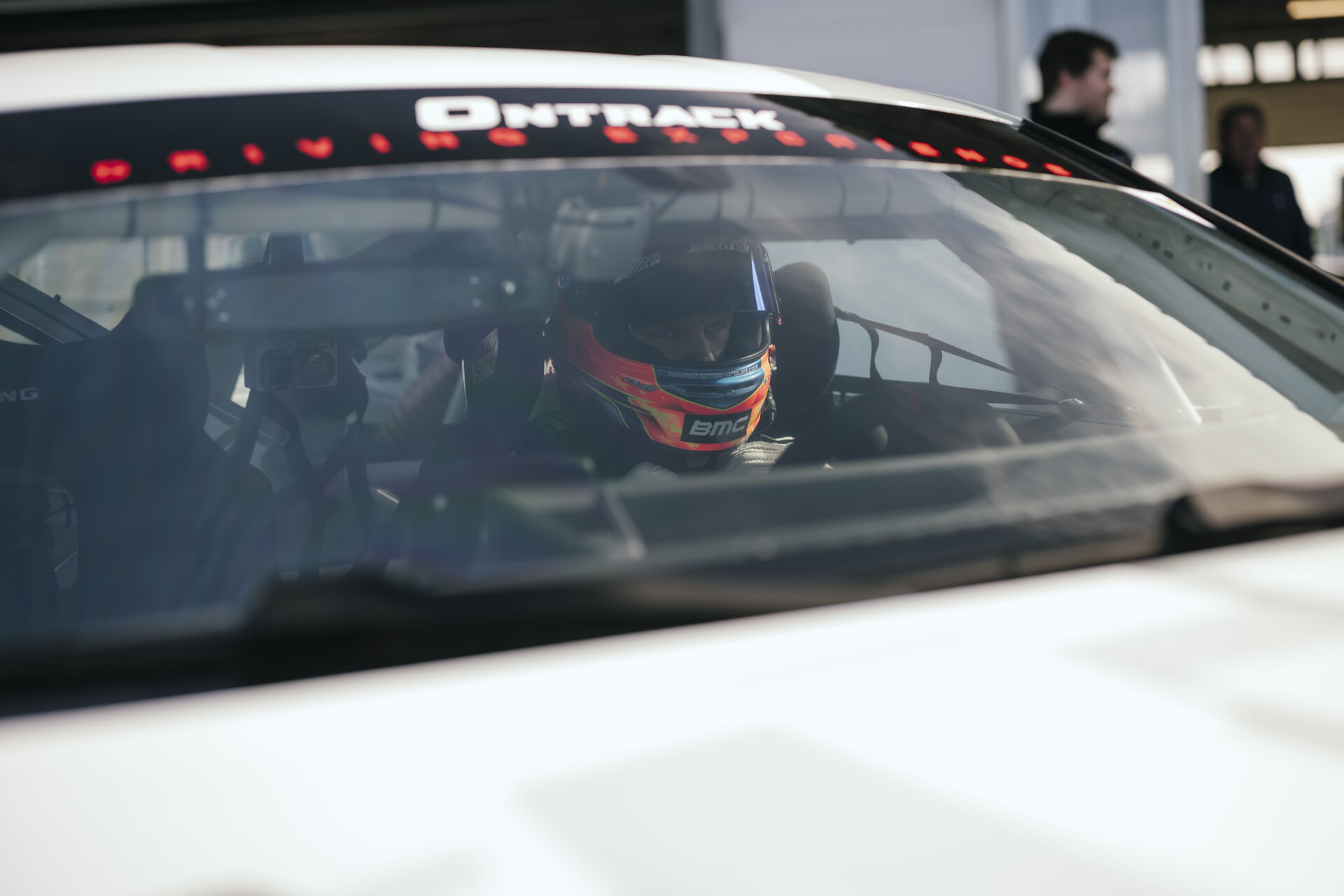 Pilote casqué dans le cockpit BMW ONTRACK, prêt pour le baptême de piste